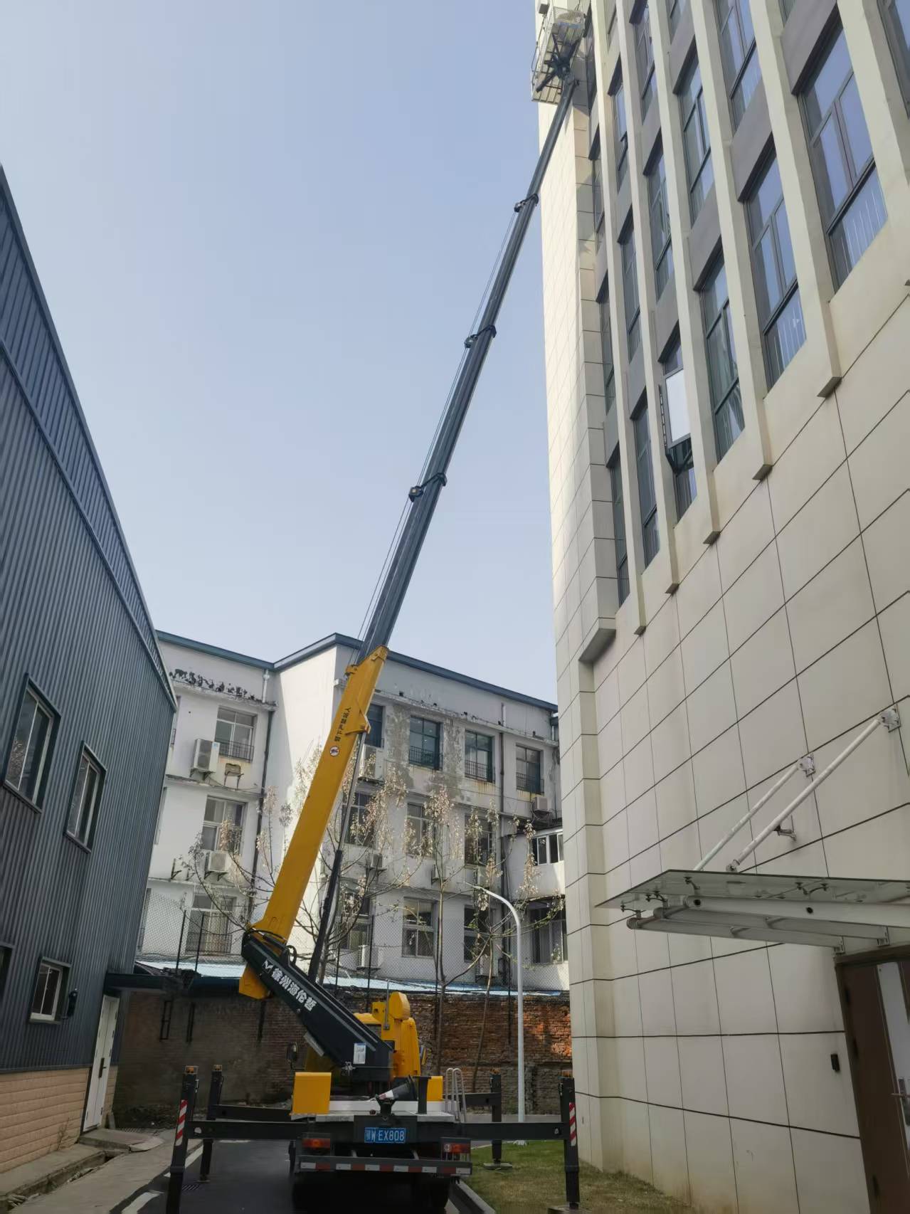 28米登高车载人拆卸外墙玻璃施工现场